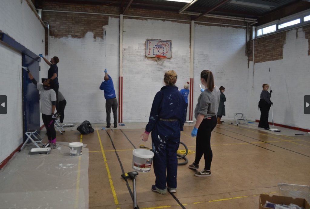 Volunteers painting a sports hall
