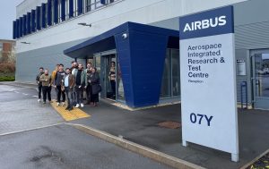 Group photo of students outside the entrance of Airbus